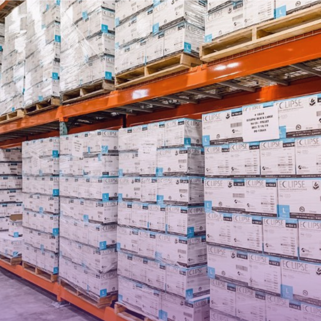 Under "BUILDING EFFICIENCY Through Streamlined Medical Supply Distribution": Tall orange metal warehouse racks are meticulously filled with numerous stacks of white and light blue medical supply boxes, neatly organized on pallets, illustrating an efficient and streamlined distribution system.