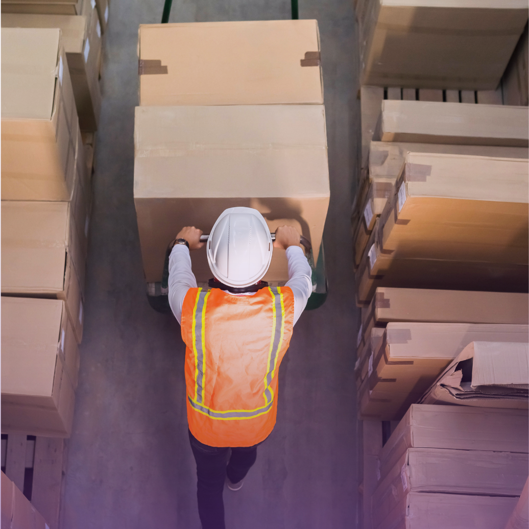 Warehouse worker with pallet jack and boxes, symbolizing optimized logistics and future distribution goals.