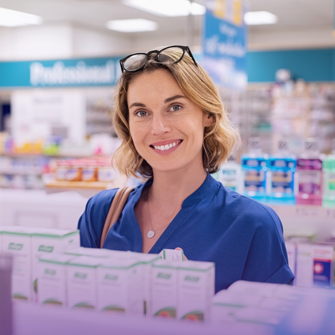 Smiling woman in a medical supply aisle, symbolizing a friendly and compliant service.