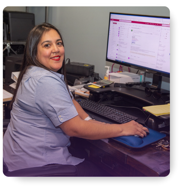 Smiling woman works at a computer, symbolizing the SANAS Portal's user-friendly interface for effortless ordering.