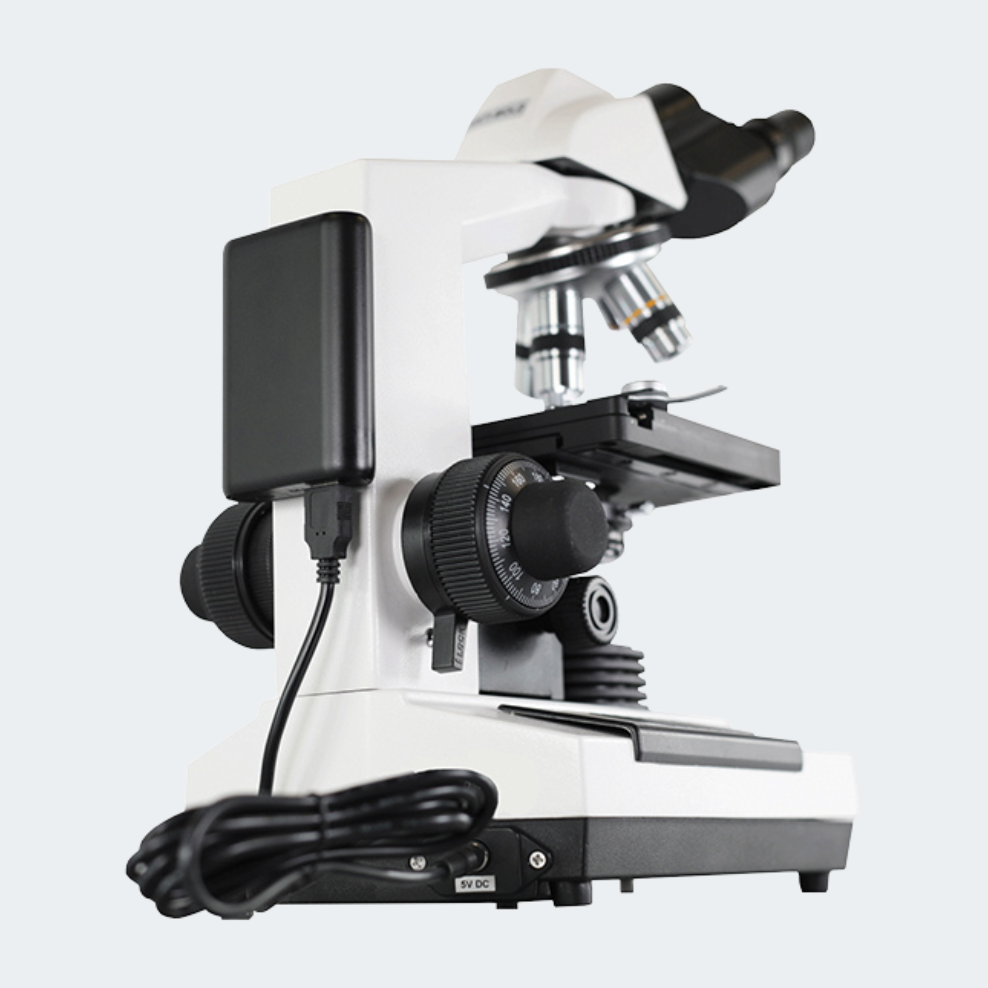 A white and black compound microscope with an attached power supply and coiled power cord, shown on a light gray background.