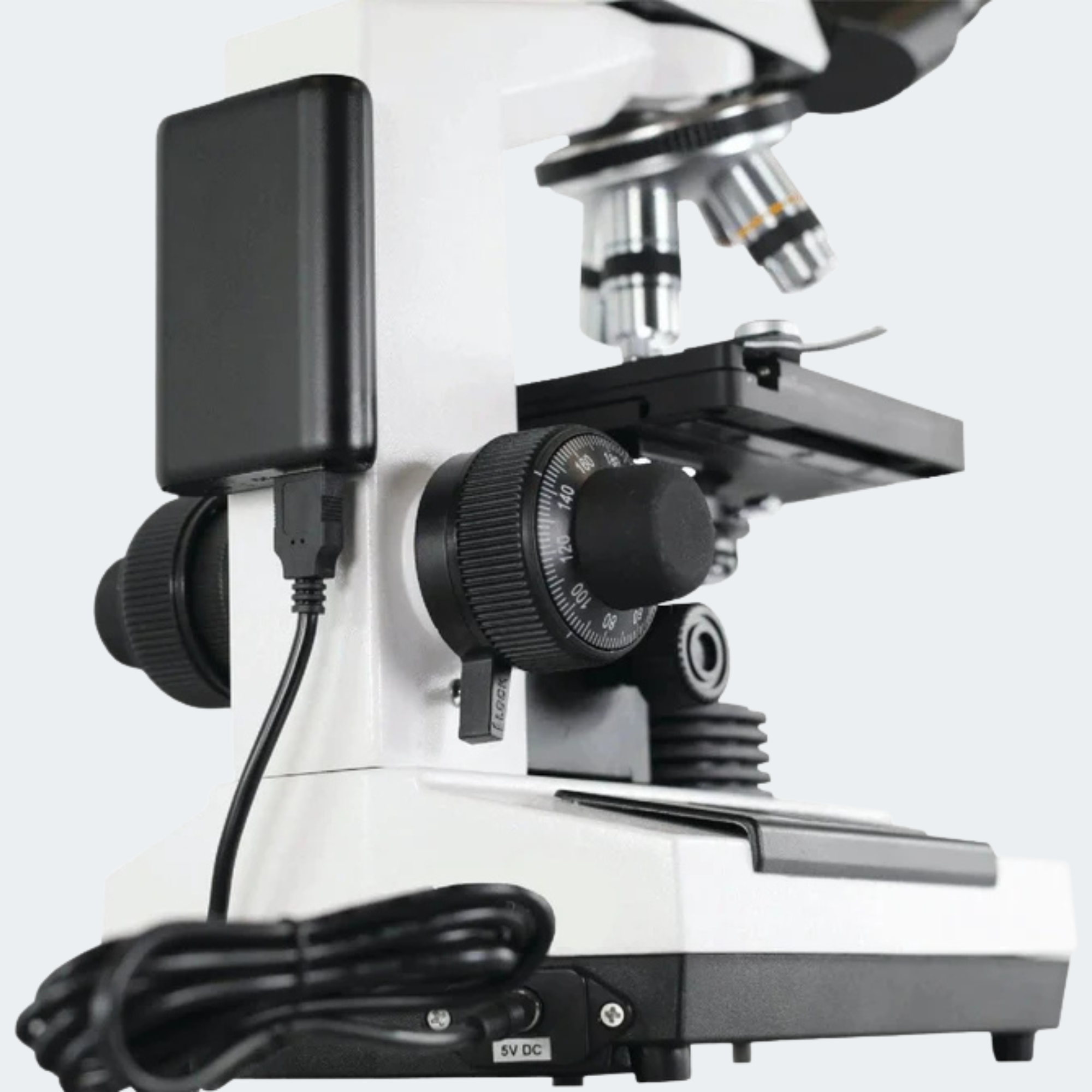 White and black scientific microscope with an attached black power supply and coiled power cord, shown on a clean light gray background.