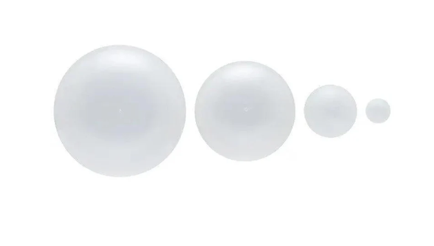 Four white spheres of varying sizes on a white background