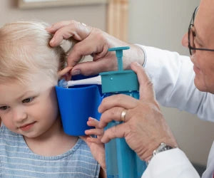 Doctor examining a child's ear with medical equipment