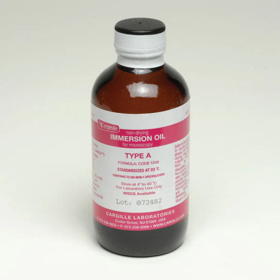 Bottle of immersion oil with a white label on a light gray background